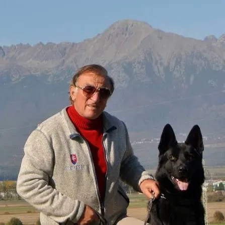 Ján Sudimák with a black German Shepherd in front of the High Tatras